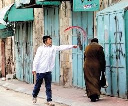 "نيويورك تايمز" تفضحهم.. مستوطن يرشق مواطنة بالخمر وسط الخليل