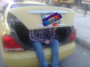 بالصورة .. سائق تكسي يحمل ركاب في الصندوق الخلفي!!