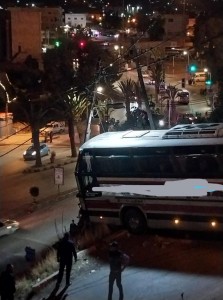 بالصور ... حافلة سياح تعلق بطريق ضيق في جرش